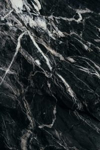 Close-up of black marble rock with white vein patterns, perfect for backgrounds.